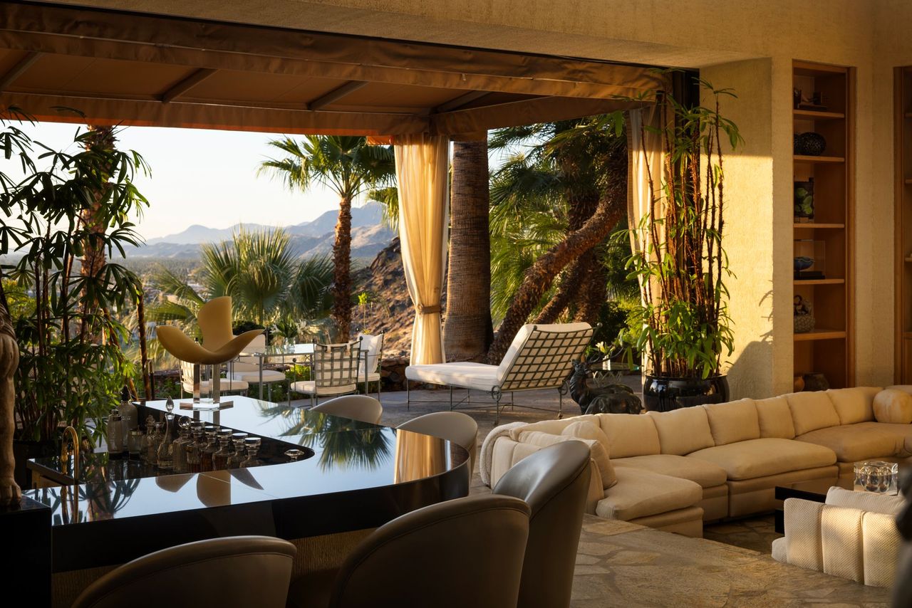 Main residence interior with curved bar and mountain-facing terrace