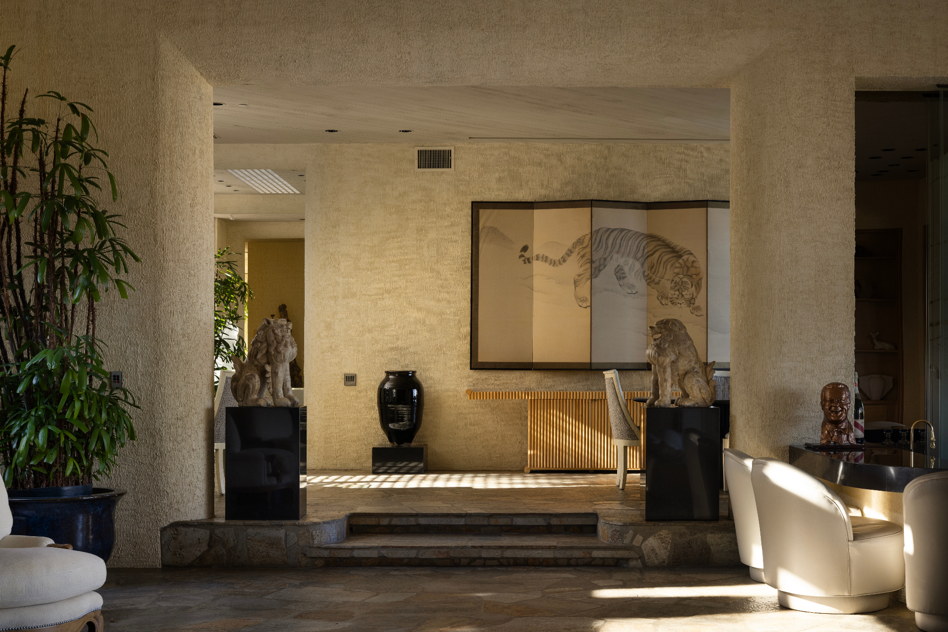 Main residence interior vignette framed by guardian sculptures and artwork