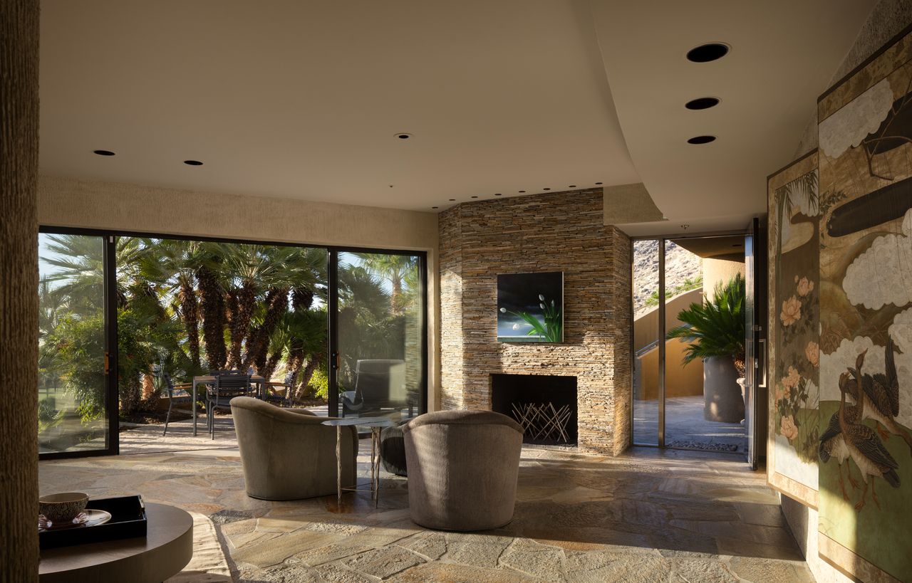 Guesthouse great room with stone fireplace and folding glass walls