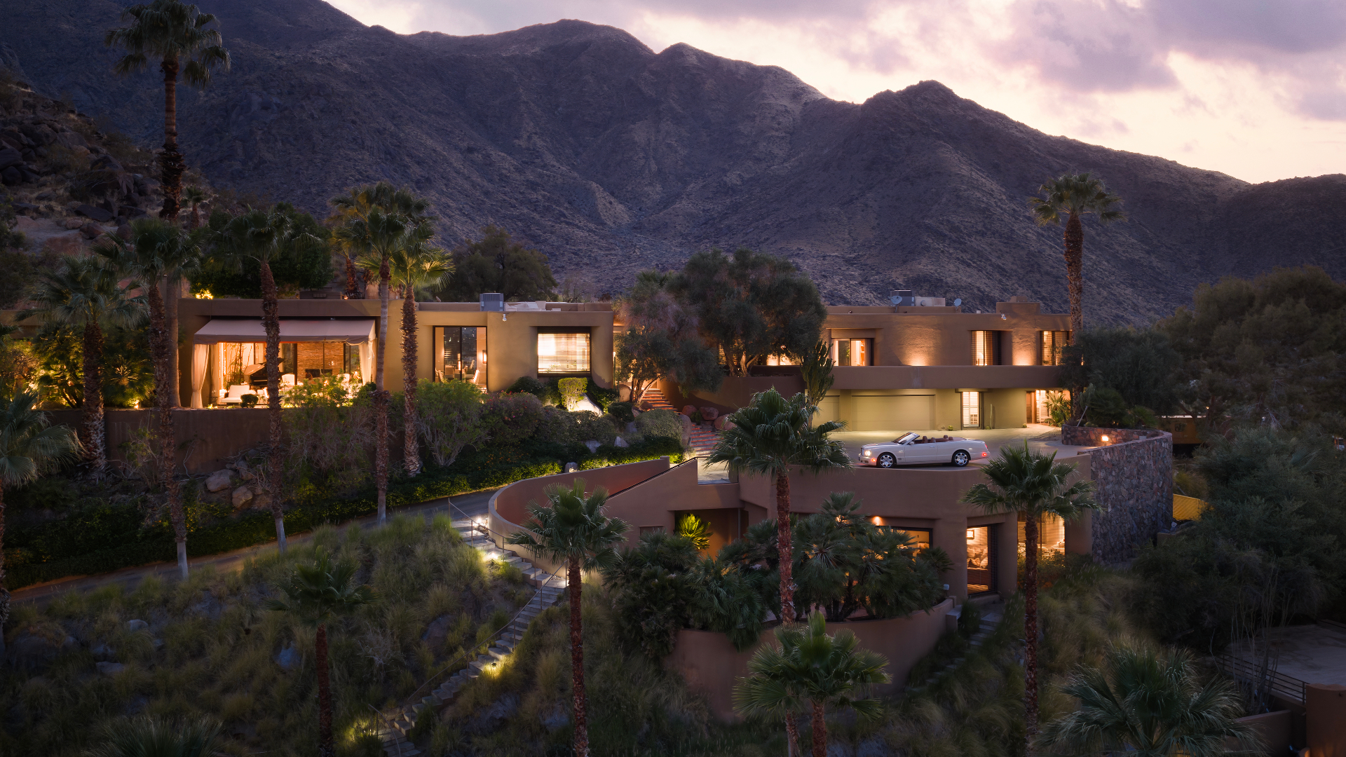 Main residence exterior at dusk against the mountain backdrop